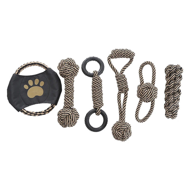 Set of dog toys including a black mask with a paw print and various rope toys on a white background.