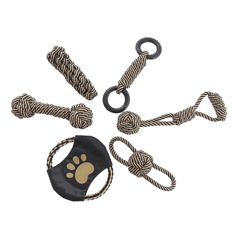 Set of dog toys including a rope toy, chew stick, and other interactive items on a white background