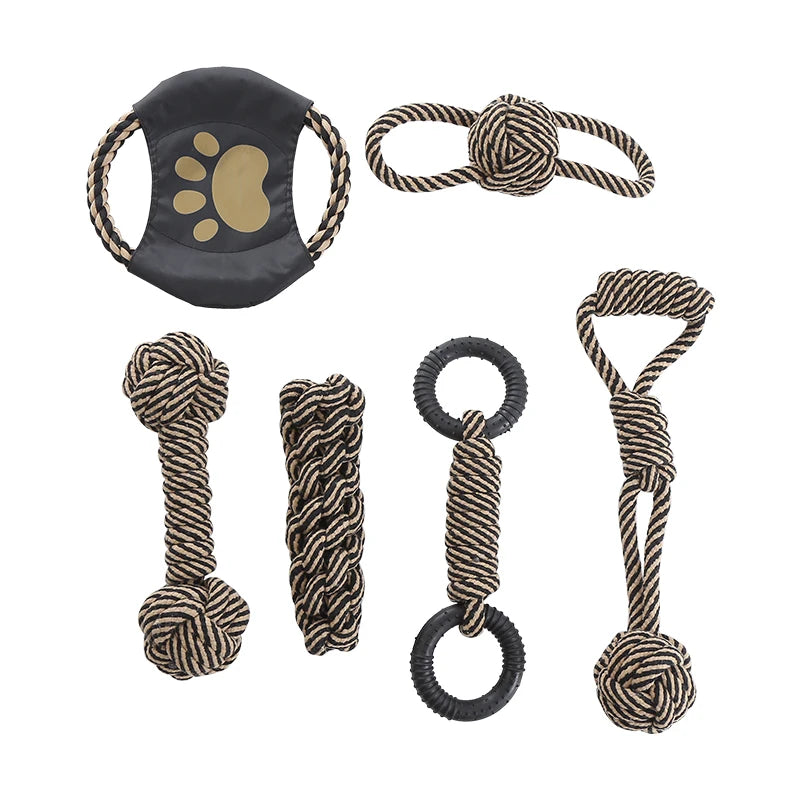 Set of dog toys including a black and gold paw print toy, rope toys, and bone-shaped toys on a white background.