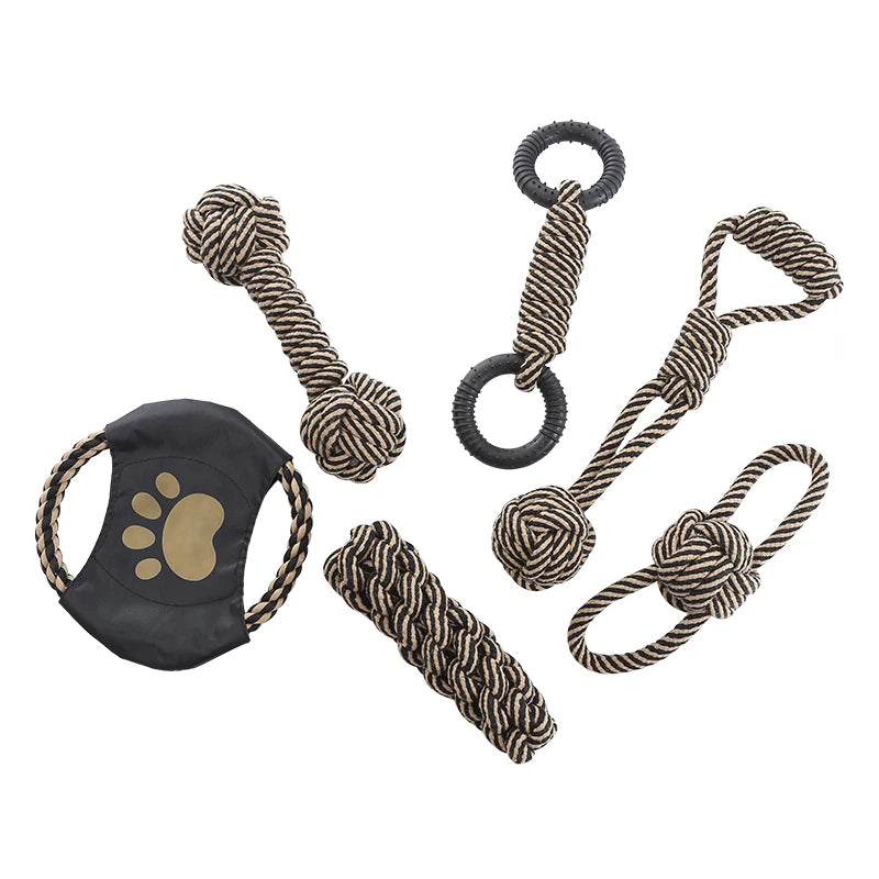 Set of dog toys including a knotted rope bone, ring, and other chew items on a white background